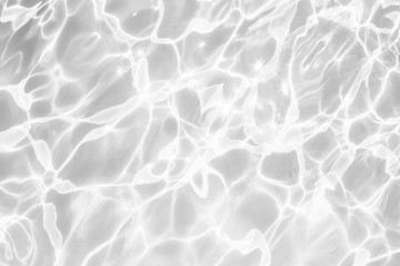 Closeup of desaturated transparent clear rough water surface texture with splashes and bubbles. Trendy abstract nature background. 