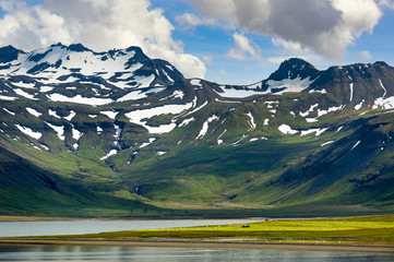 Wall Mural - Countryside of iceland Panoramic mountain view On the top of the mountain there is still some snow. In the summer there is green grass. The front scene is a meadow and lake.