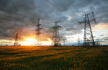 Silhouette High voltage electric towers at sunset time. High-voltage power lines. Electricity distribution station