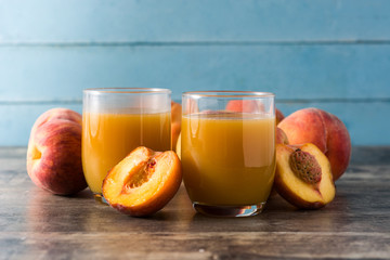 Wall Mural - Natural peach juice in glass on wooden table	