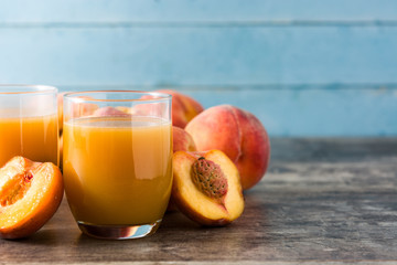 Wall Mural - Natural peach juice in glass on wooden table	