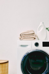 Wall Mural - detergent bottle and towels on washing machine near laundry basket in bathroom