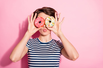 Closeup photo of attractive funny lady hold hands two sweet baked donuts like specs near eyes sending air kisses wear casual white blue t-shirt isolated pastel pink color background