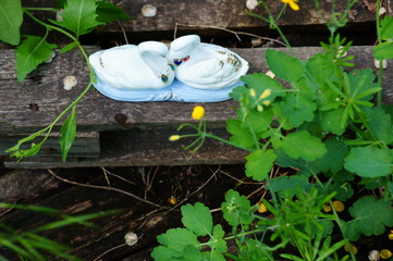 Sticker - A pair of souvenir swans on a wooden surface.