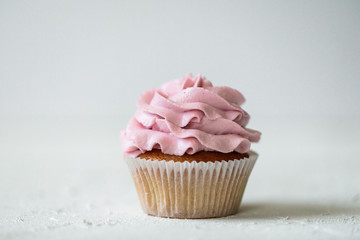 cupcake with pink cream on a white background, free space for text, homemade pastry
