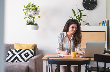 Woman working on laptop computer from home stock photo