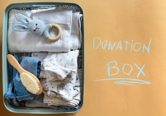 Donation box with eco Baby Boy clothing and donation accessories. Flat lay