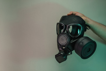 Poster - Hand hold black old gas mask in the color light. Beautiful old minimal in neon light. Minimalism retro style concept. Background pattern for design.