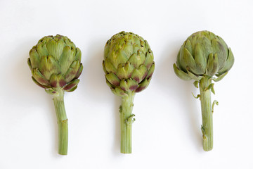 Wall Mural - Fresh green Italian Artichoke isolated on white background. Organic local produce vegetable on table top. Vegan diet. Clean eating concept. Close up, top view, flat lay.