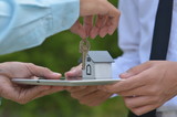 Fototapeta  - businessman with house model and keys, real estate agent with house model and keys