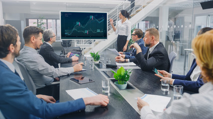Poster - In the Corporate Meeting Room: Female Analyst Uses Digital Interactive Whiteboard for Presentation to a Board of Executives, Lawyers, Investors. Screen Shows Company Growth Data with Graphs