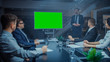 © Gorodenkoff - Late at Night In the Corporate Meeting Room: Director Talks and Uses Digital Chroma Key Interactive Whiteboard for Presentation to Executives, Investors. Green Mock-up Screen in Horizontal Mode