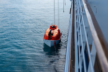 Lowering Orange Lifeboat To Water In Arctic Waters, Svalbard. Abandon Ship Drill. Lifeboat Training. Man Over Board Drill.