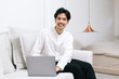 © Gengwit - Attractive asian male working with computer laptop at home. Analyzing online data to success business