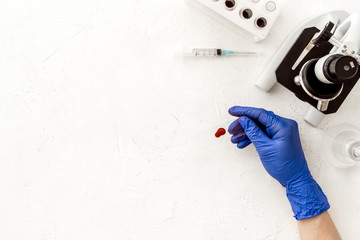 Wall Mural - Blood testing with microscope in laboratory. Sample in hands on white background top view copy space