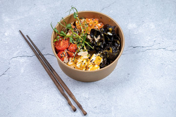 Wall Mural - Hawaiian salmon fish poke bowl with rice, radish,cucumber, tomato, sesame seeds and seaweeds. Buddha bowl. Diet food