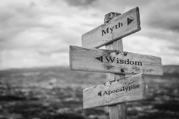 myth wisdom apocalypse text engraved on old wooden signpost outdoors in nature. quotes, words and il