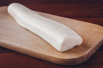 Soft cheese Suluguni on plate on wooden table