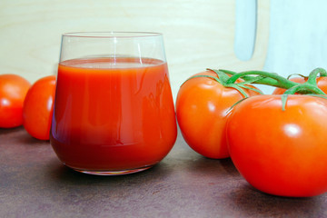 Fresh tomatoes and a full glass of tomato juice. Healthy healthy product, dietary