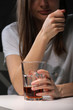 © Andriy Medvediuk - Close up of woman sitting and holds glass with whiskey or cognac having alcohol addiction, depressed female drinking strong alcohol suffering from personal relationships problems