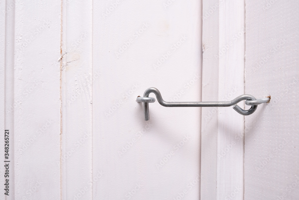 A locked metal door hook on white wooden door simple device for home house safety and protection Stock Photo Adobe Stock