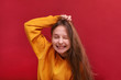 © Evgenia - A broad smile of a girl in a sweater on a red background.