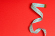 Tangled measuring tape with space for your idea. Sewing and tailor concept on red background