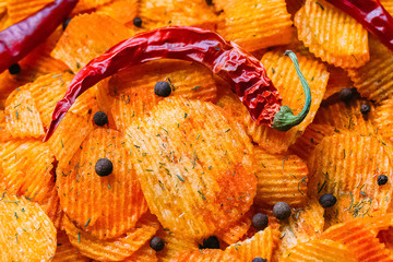 Fluted chips with chili and paprika. Background of chips with spices.