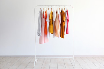 fashion clothes on a stand in a light background indoors. place for text