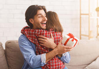 Wall Mural - Emotional young father hugging daughter, holding gift box