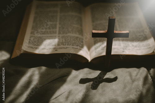 Cuadros en Lienzo Crucifixion of Jesus christ ,cross with the holy bible at sunlight
