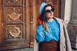Spring vintage retro fashion female accessories and clothes. Woman wearing sweater beret leather skirt on street.