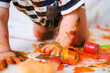 © FOTO_STOCKER - Cropped cheerful grimy baby crawls on the floor playing with paint. dirty kid close up. Happy leasure and play at home.