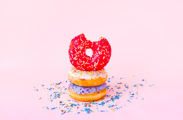 Wall Mural - Colored donuts with colorful sprinkles on pink background. National Donut or Doughnut day concept. Close-up