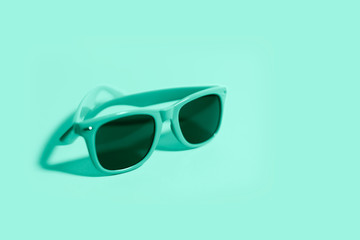 Wall Mural - Close-up of sunglasses on background of aqua menthe color.