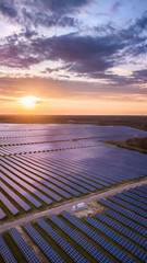 aerial view of solar panels on green lawn on sunset. drone shot, bird's eye...