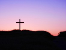 Low Angle View Of Silhouette Cross On Hill Against Clear Sky At Sunset