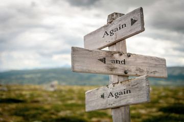 again and again text engraved on old wooden signpost outdoors in nature. Quotes, words and illustration concept.