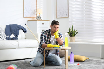 Canvas Print - Lazy man procrastinating while cleaning at home