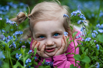 two year old girl with forget-me-nots flowers