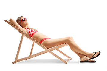 Wall Mural - Young woman in bikini sunbathing on a lounge chair