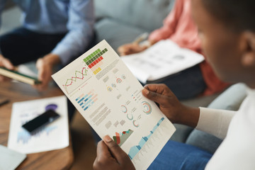 Wall Mural - high angle view of unrecognizable businessman holding statistics report while working on startup pro