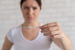 © Михаил Решетников - Unhappy woman shows a quick negative test for ovulation. The concept of violation of female reproductive function. Frustrated girl. Luteinizing hormone.
