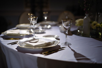 in a restaurant with a dark light, a table is set up, a bunch of light falls on the dishes