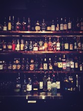 Liquor Bottles On Shelf In Bar