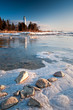 Sunrise light on Cana Island lighthouse and the Lake Michigan shoreline on a winter morning in Door County, Wisconsin.