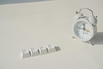 Time word composed of keyboard keys, clock on grey background, copy space