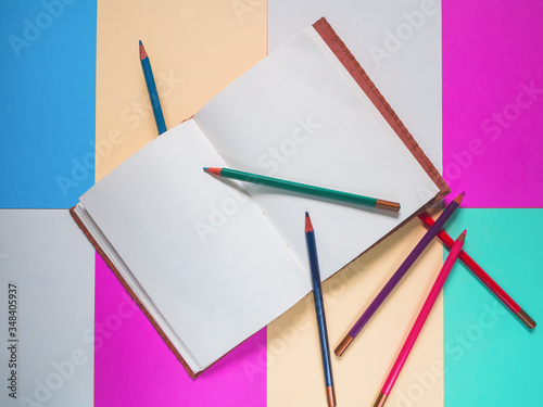 Notebook on a color background and color pencil collection © touch_of_eyes