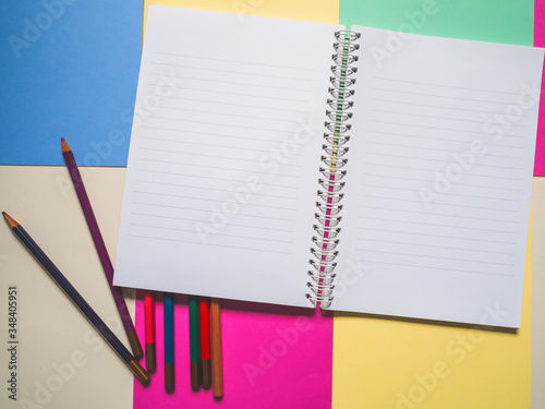 Notebook on a color background and color pencil collection © touch_of_eyes