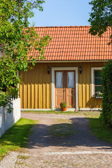 Wall Mural - Small cottage in an alley with cobblestones